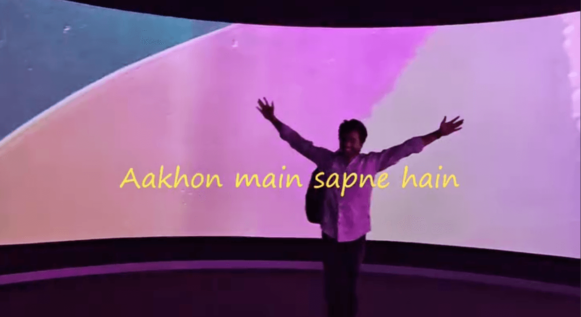 Arms outstretched in front of a glowing screen